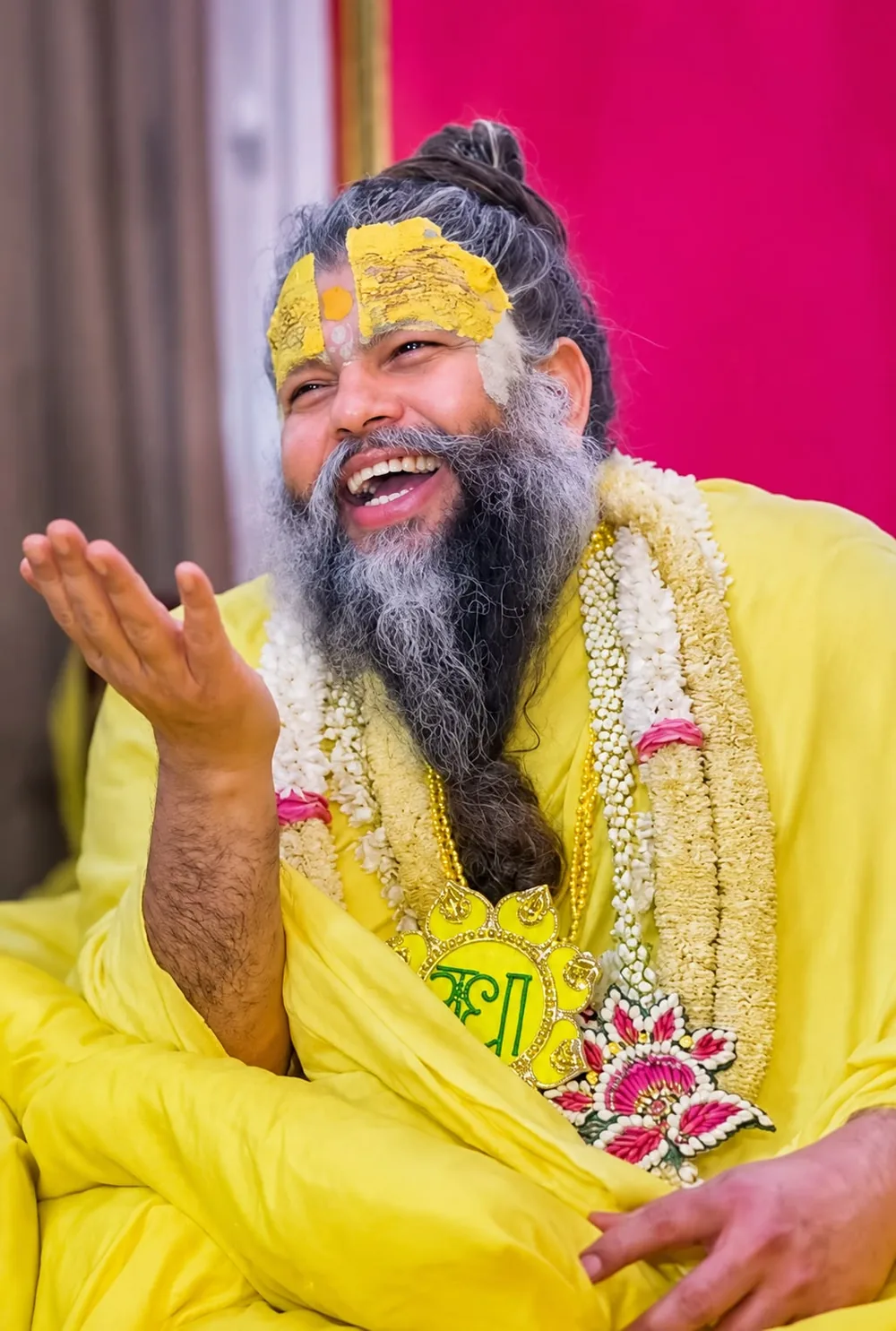 Premanand Ji Maharaj laughing during morning satsang, wearing jasmine garlands at Shri Hit Radha Keli Kunj, Vrindavan