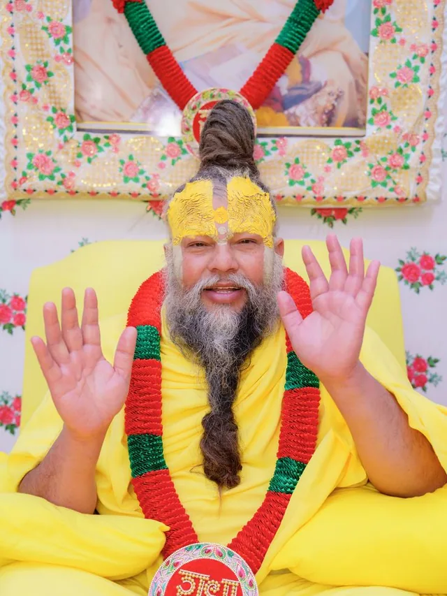 Premanand Ji Maharaj with both hands raised, blessing devotees at Shri Hit Radha Keli Kunj, Vrindavan
