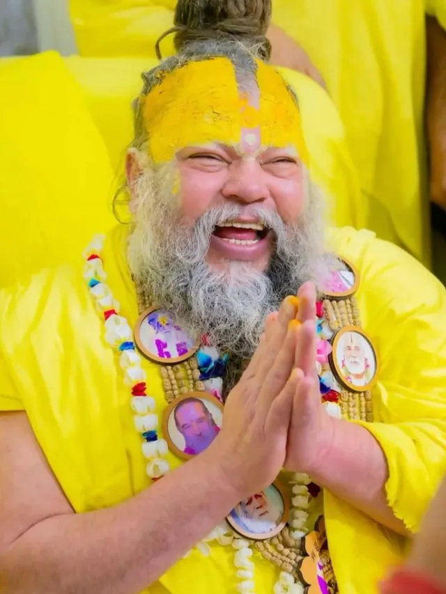 Premanand Ji Maharaj with hands folded beside the microphone at Shri Hit Radha Keli Kunj, Vrindavan