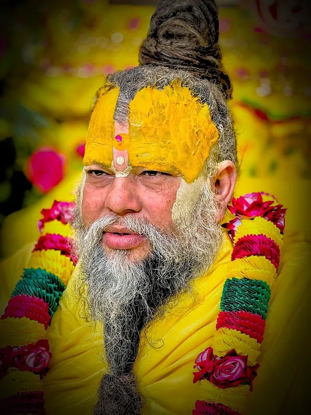 Premanand Ji Maharaj close portrait with a green and red garland at Shri Hit Radha Keli Kunj, Vrindavan