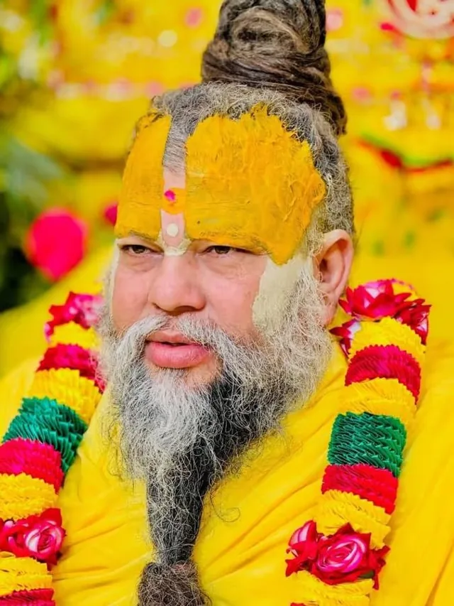 Premanand Ji Maharaj wearing a marigold and green garland at Shri Hit Radha Keli Kunj, Vrindavan