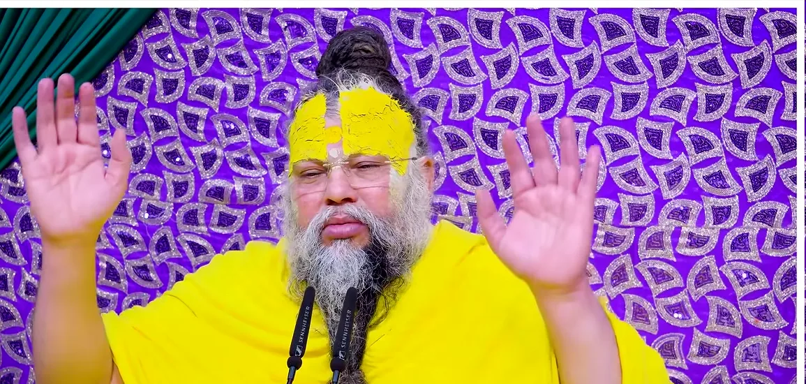 Premanand Ji Maharaj both hands raised before a purple backdrop