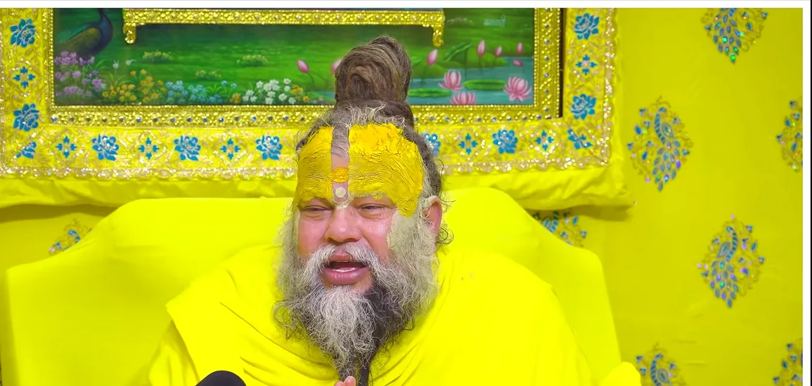 Premanand Ji Maharaj a calm portrait before a green and gold backdrop