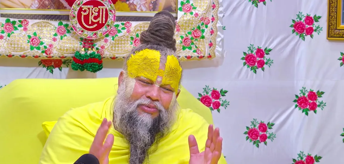 Premanand Ji Maharaj hand raised, floral backdrop