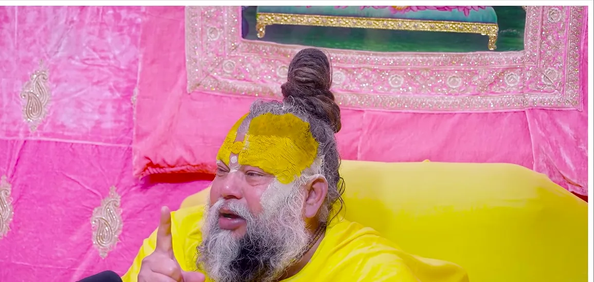 Premanand Ji Maharaj a portrait before a rose pink backdrop