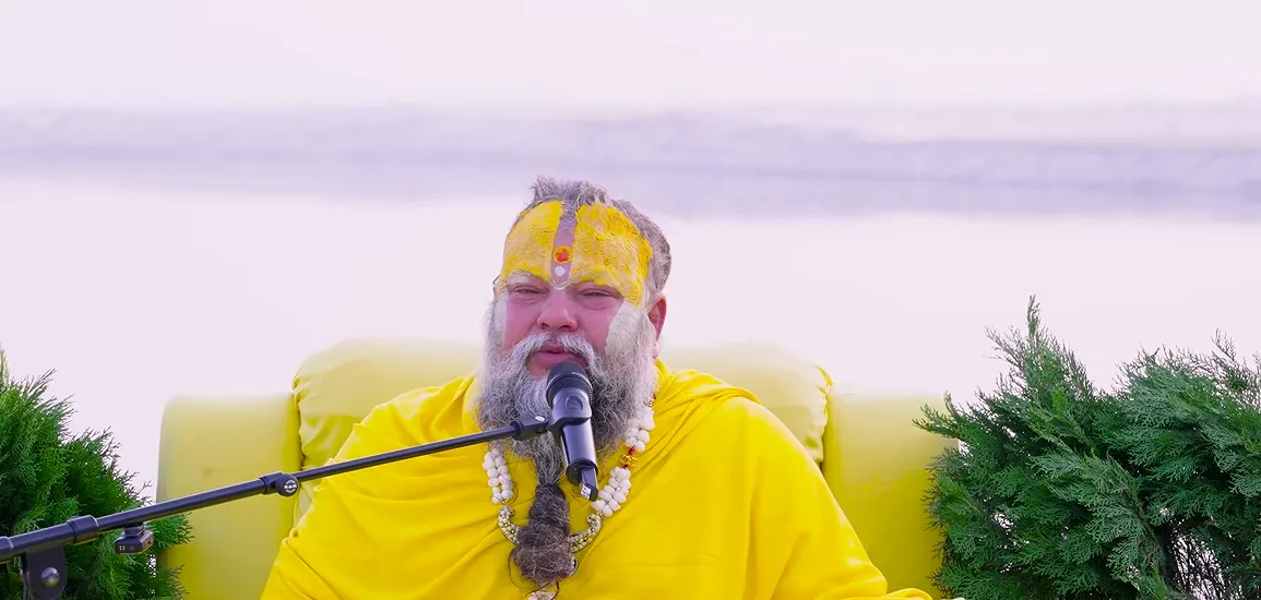 Premanand Ji Maharaj seated for satsang beside the water at dawn