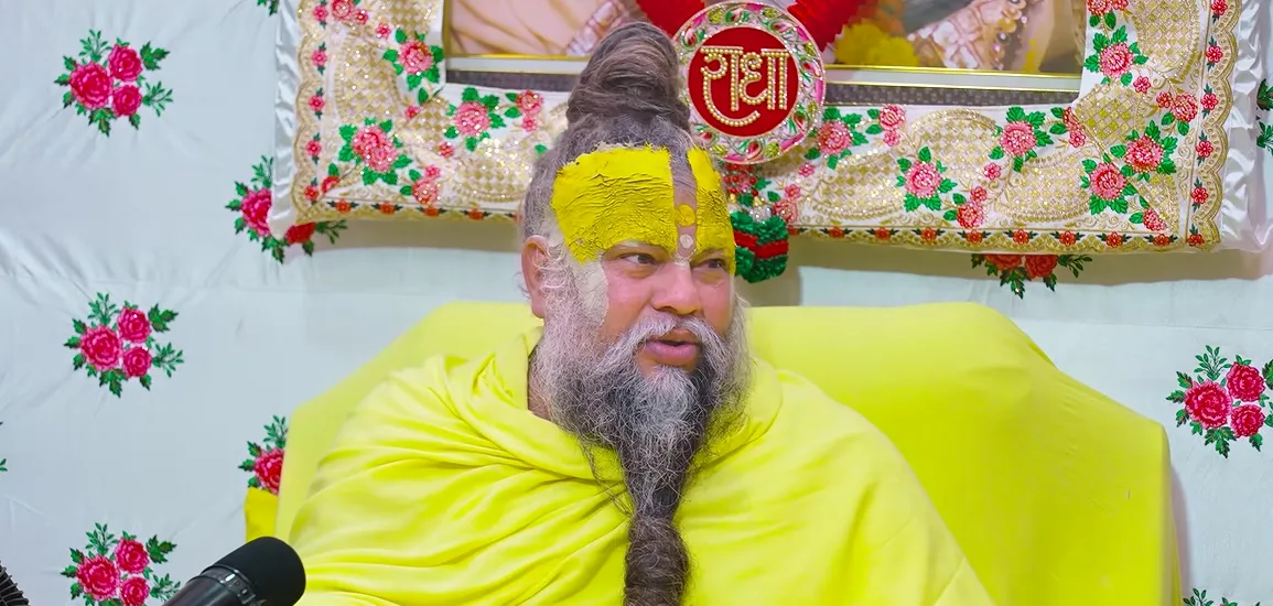 Premanand Ji Maharaj seated calmly against the floral backdrop