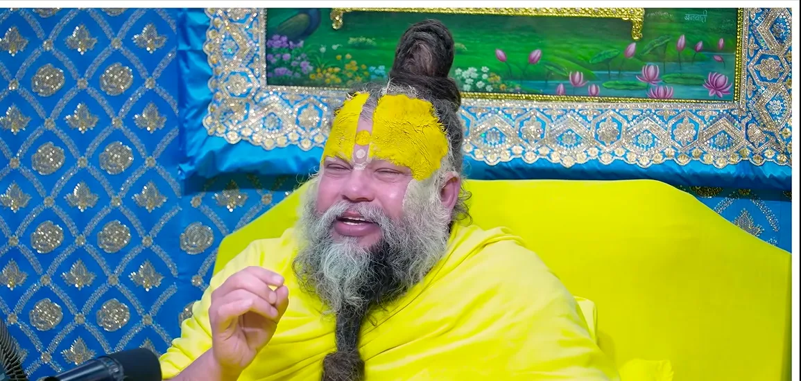 Premanand Ji Maharaj speaking before a blue and gold backdrop