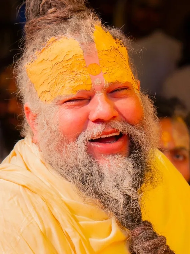 Premanand Ji Maharaj smiling in a close portrait at Shri Hit Radha Keli Kunj, Vrindavan